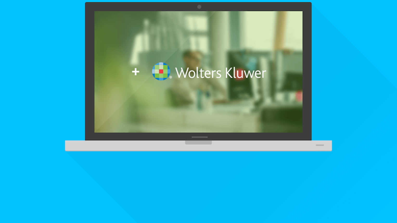Laptop som visar Wolters Kluwers logotyp över en suddig kontorsbild